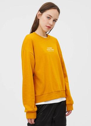 Женский свитшот горчичного цвета от бренда "bershka" с принтом по центру " i am famous an social media", размер s.