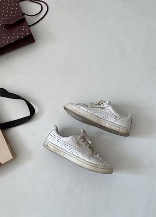 Білі кросівки — модель puma court star, що вирізняється перфорацією з боків та зеленою усталена
