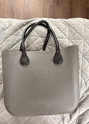 Це сіра сумка бренду o bag моделі classic з темними ручками. матеріал: корпус виготовлений з екологічного та зносостійкого матеріалу xl extralight