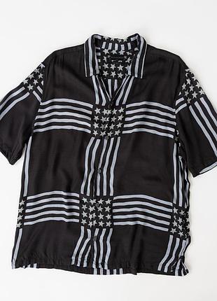 Чоловіча сорочка allsaints чорного кольору з контрастним, білим принтом у вигляді стилізованого прапора сша. модель має вільний крі