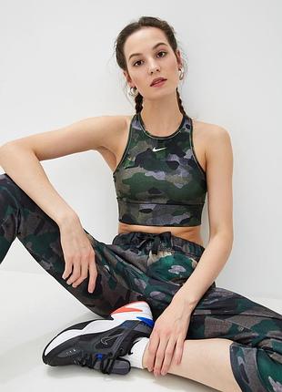 Жіночий, спортивний топ nike dri-fit із камуфляжним принтом у зелених, чорних та сірих відтінках. модель має зручний крій racerback, еластичну нижню с
