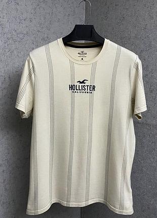 Бежева смугаста футболка від бренду hollister