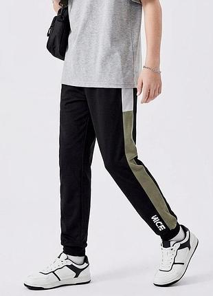 Сучасні стильні підліткові спортивні штани в стилі streetwear.чорні з оливковими вставками вздовж бічного шва.завужені до низу.ріст 150 см