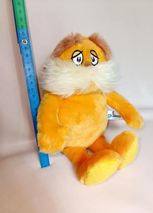 Плюшева іграшка aurora dr. seuss the lorax, відома своїми великими вусами та жовто-помаранчевим хутром.