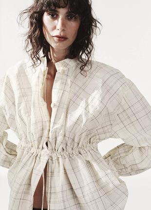 Белая куртка-рубашка zara. имеет регулируемую талию на кулиске и высокий воротник.