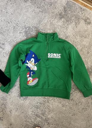 Це зелений дитячий світшот із блискавкою на горловині та принтом sonic the hedgehog від бренду sinsay