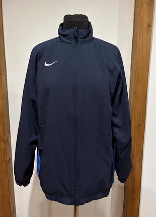 Темно-синя спортивна куртка nike dri-fit має легкий вологовідвідний матеріал та контрастні сині вставки з боків.