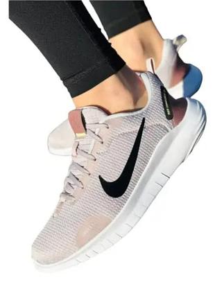 Жіночі кросівки nike flex experience run 12 бежевого кольору з чорним логотипом.