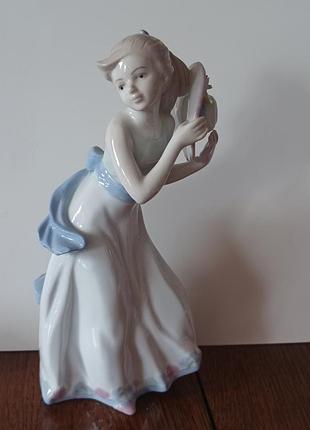 Винтажная фарфоровая статуэтка, похожая на изделия производителя nao by lladro, изображает девушку с шляпкой в руках, в длинном белом платье.