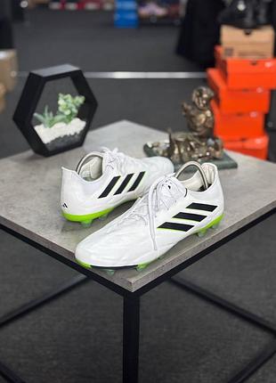 Футбольні бутси adidas copa pure.1 fg, виконані в білому кольорі з чорними смужками.