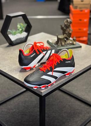 Футбольні бутси adidas predator 24 league low у чорно-білому кольорі з яскраво-червоними шнурками.