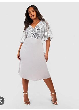 Вечернее платье boohoo имеет серебристый лиф с пайетками и рукавами-крылышками.