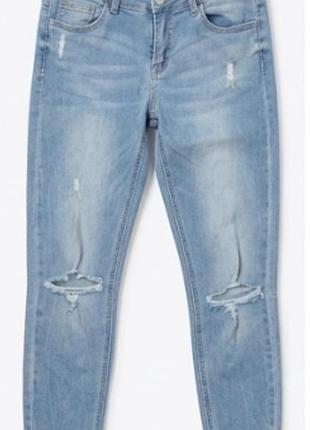 Жіночі світло-блакитні джинси скіні (skinny jeans) з рваними елементами (розрізами на колінах) та потертостями.