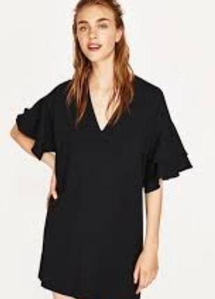 Коротка чорна сукня від zara має v-подібний виріз і вільні рукави з рюшами.