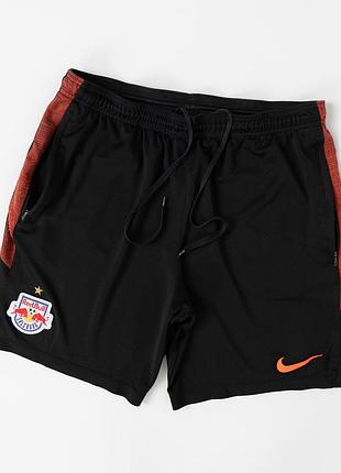 Чоловічі, спортивні шорти nike red bull salzburg чорного кольору з помаранчевими вставками. модель виконана з легкої, поліестерової тканини, має еласт
