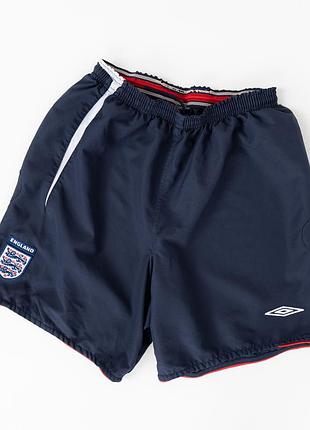 Чоловічі, вінтажні, спортивні шорти umbro england у темно-синьому кольорі. модель початку 2000-х років із вишитою емблемою збірної англії,