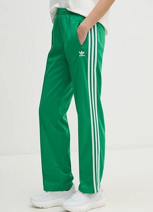 Жіночі, спортивні штани adidas яскравого, зеленого кольору з фірмовими трьома білими смужками з боків. модель оснащена еластичним поясом для комфорт
