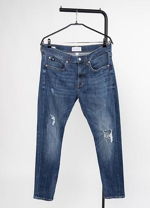 Чоловічі джинси calvin klein jeans синього кольор у фасоні slim taper. виготовлені з деніму з додаванняо забезпечує комфортну посадку та свободу рухів