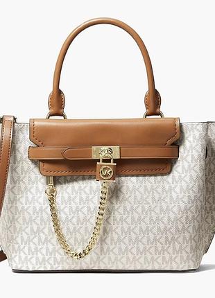 Оригінальна сумка michael kors виконана в бежевому кольорі з коричневими шкіряними деталями та характерним золотистим ланцюжком.
