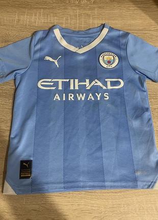 Дитяча футболка puma manchester city 23/24 home replica блакитного кольору з білими акцентами.