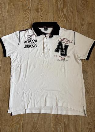 Чоловіча футболка-поло від бренду armani jeans має білий колір, чорний комір та великий фірмовий логотип "aj" на грудях