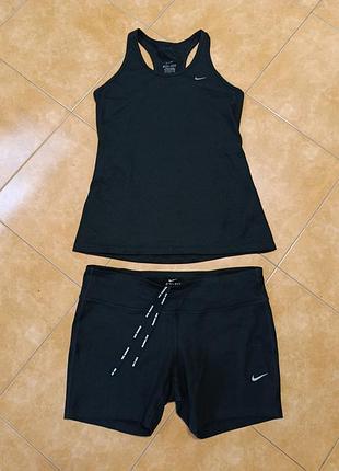 Жночий спортивний комплект nike dri-fit чорного кольору, який складається з бігової майки та облягаючих шортів.