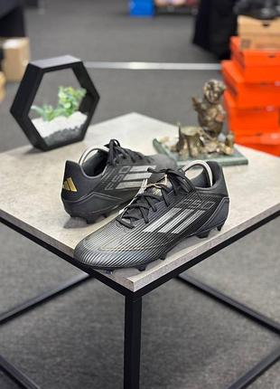Чорні футбольні бутси adidas f50 league fg/mg (артикул ie3181), призначені для гри на натуральних і штучних покриттях.