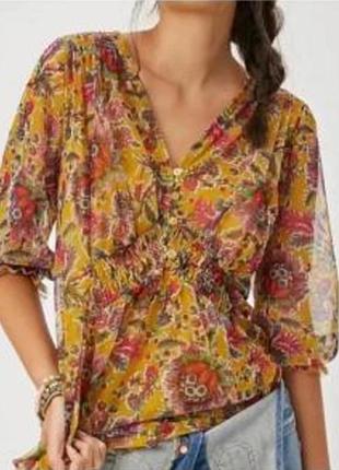 На зображенні представлена напівпрозора блузка-туніка "gretchen smocked tunic" від бренду anthropologie.