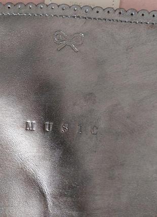 Серебристый клатч-косметичка aпуа
hindmarch имеет надпись "music"