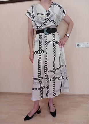 Женское платье от zara.есть пояс,сбоку молния.впереди хомут,рукав спущеный,юбка полусолнце с разрезами..на белом фоне черный рисунок цепи.