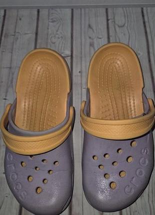 Детские сабо crocs electro, выполненные в лавандовом цвете с контрастным оранжевым ремешком.