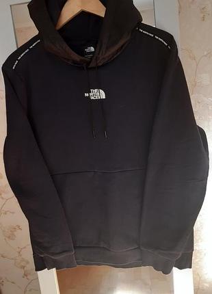 Темно синя худорлявість від the ​​north face відрізняється унікальним брендингом у вигляді стрічки з логотипом, що проходить капюшоном і рукавами.