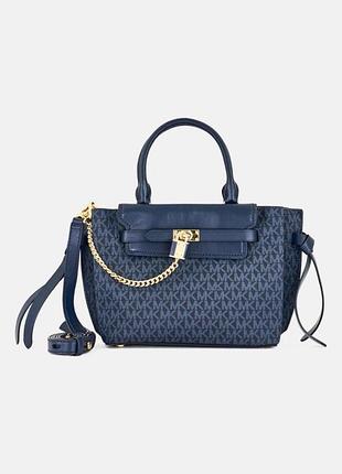 Жіноча сумка michael kors hamiltonsmall,виконана втемно-синьому кольорі з фірмовим логотипним принтом та характерним декоративним замком із ланцюжком.