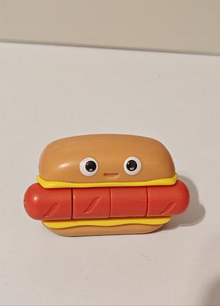 Игрушка-антистресс — fidget go hot dog от one for fun, выполненная в виде улыбающегося хот-дога с сегментированной сосиской.