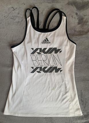 Біла жіноча майка adidas runner city night 2020 має чорну графіку "run berlin run" на передній частині.