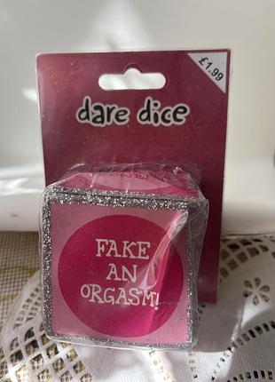Гральні кубики "dare dice" (кубики з завданнями), оформлені в рожевому кольорі з блискітками.кубик містить завдання "fake an orgasm!"