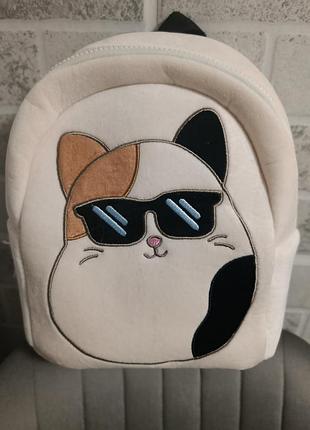 Плюшевий рюкзак виконаний у вигляді персонажа cam the cat від бренду squishmallows