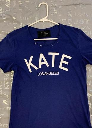 Синя футболка zara з написом "kate los angeles" та декоративними ґудзиками біля горловини.