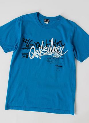 Чоловіча футболка quiksilver у яскравому, блакитному кольорі з великим, фірмовим, графічним принтом на грудях та невеликим логотипом на спині. вигото