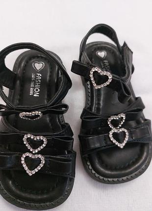 Детские босоножки черного цвета от бренда fashion украшены декоративными сердцами