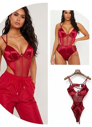 Боди от бренда prettylittlething, выполненное из красного атласа с прозрачными вставками из сетки и проволочным каркасом.