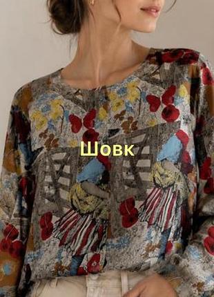 Ця вінтажна  шовкова блузка з довгим рукавом має унікальний графічний принт із зображенням людей у ​​народних костюмах та квітах.