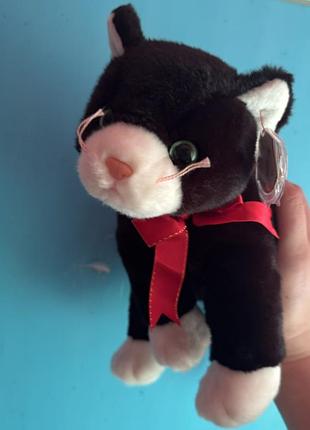 Ця м'яка іграшка — чорно-біле кошеня zip з колекції ty beanie buddy (1999 року) з червоним бантом на шиї