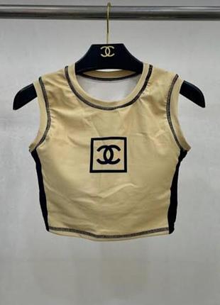 Дуже краствтй бежевий кроп-майка від chanel з колекції sport line, прикрашений чорним логотипом cc
