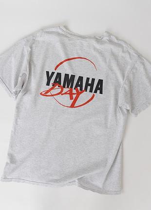 Чоловіча, вінтажна футболка yamaha day сірого кольору з логотипом yamaha спереду та великим, графічним принтом на спині. модель має класичний, кругли