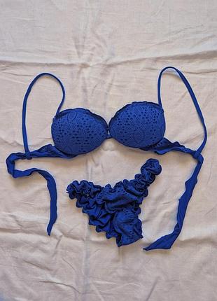 Ярко-синий раздельный купальник бренда calzedonia отличается фактурной перфорированной тканью с изящными оборками на плавках