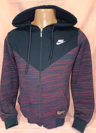 Мужская толстовка nike имеет темно-синюю верхнюю часть и красно-синий полосатый узор на рукавах и нижней части корпуса.
