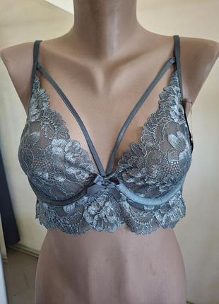 Мереживний бюстгальтер від бренду hunkemöller виконаний у темно-сірому кольорі з вишуканими портупеями.