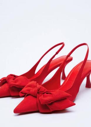 Червоні туфлі-слінгбеки бренду zara із застромленим носком та декоративним великим бантом спереду.