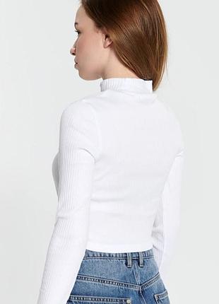 Белый базовый гольф в рубчик от бренда sinsay с воротником-стойкой (mock neck) и длинными рукавами.